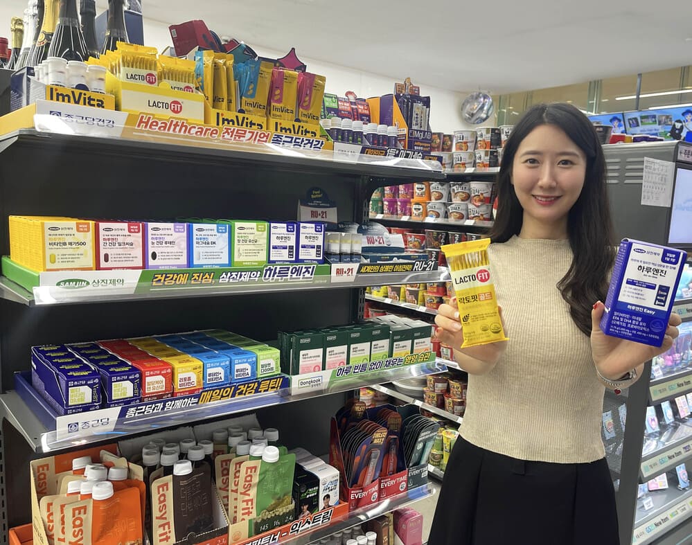 A Korean Woman Smiling in GS25 holding K-inner beauty and health product