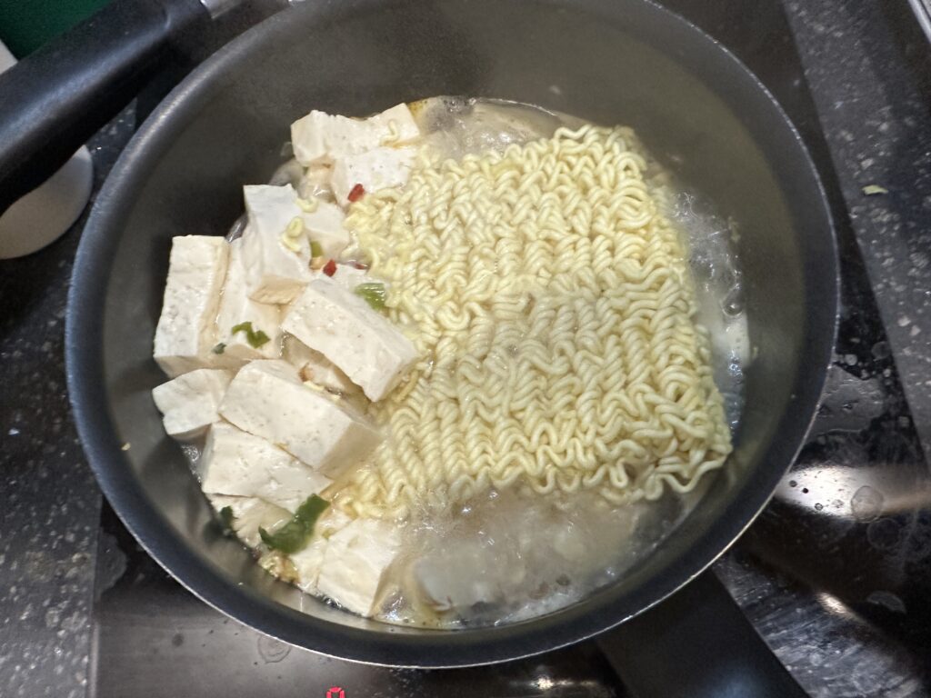 Add the dried vegetable/seasoning packet to ramen. Stir well and let it cook for 30 seconds to rehydrate the vegetables.