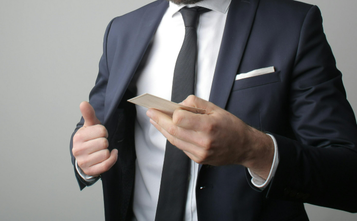 A man in suit presenting his business cards in a business meeting