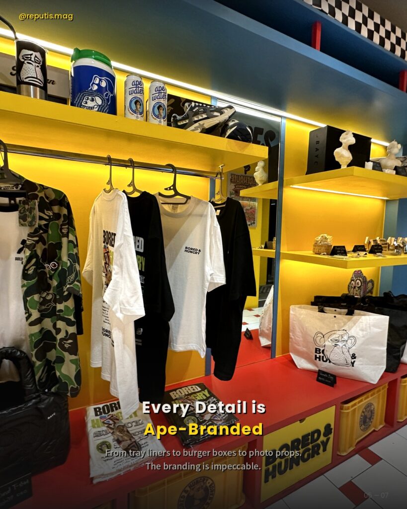 Overhead close-up of a smash burger with melted cheese, lettuce, red onion, and tomato in Bored & Hungry branded packaging. Text overlay reads "Every Detail is Ape-Branded."