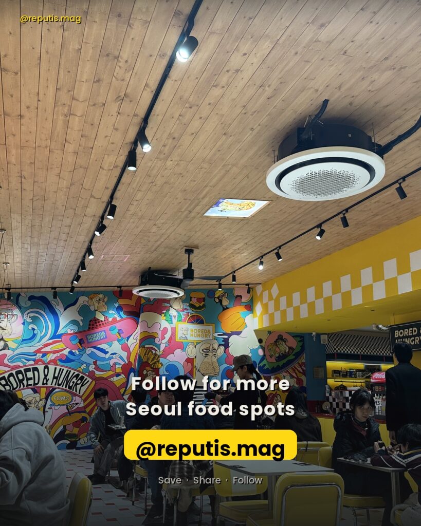 Interior photo of Bored & Hungry showing diners at yellow tables with BAYC murals in the background. Call-to-action text reads "Follow for more Seoul food spots" with @reputis.mag handle highlighted.