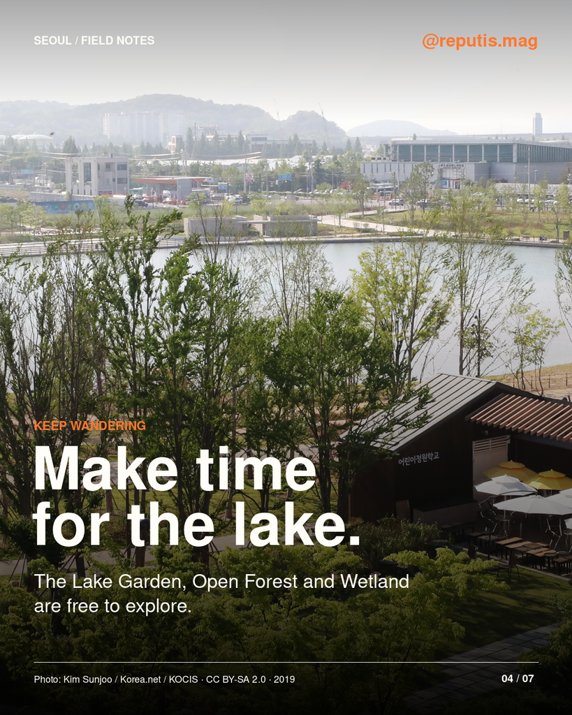 Trees, walking paths and a lake seen from above at Seoul Botanic Park.
